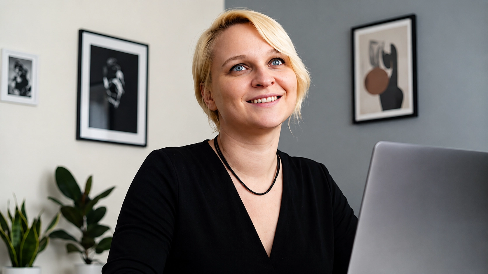 Stella Catucci sorridente davanti a un laptop durante il lavoro.